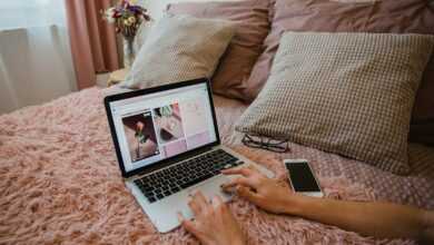person using macbook pro on bed