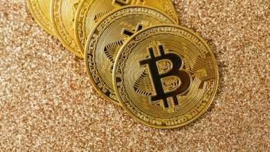 Golden Bitcoin coins arranged on a sparkling glitter surface, symbolizing cryptocurrency and wealth.