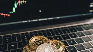 Golden Bitcoin and Litecoin coins on a laptop keyboard with a market graph in Berlin.