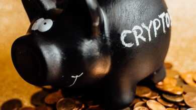 A black piggy bank labeled 'CRYPTO' surrounded by various coins on a gold background.