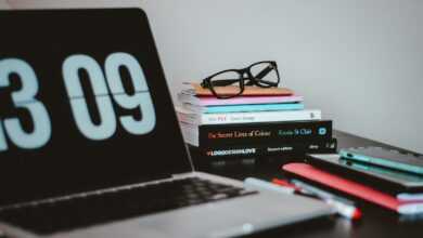 silver MacBook Pro near books