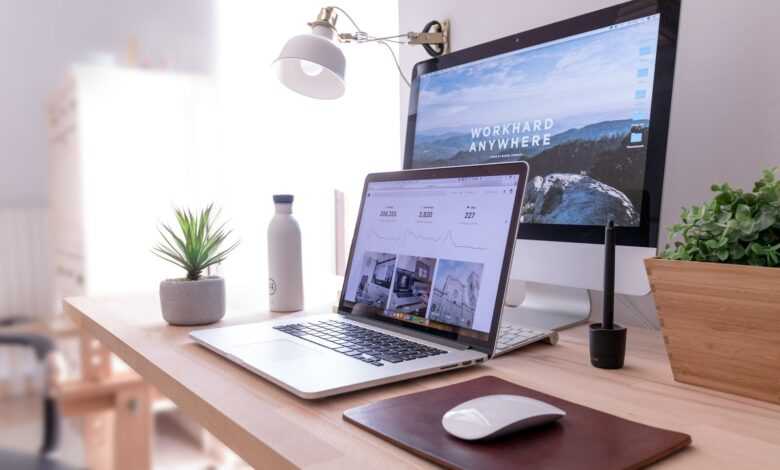 MacBook Pro on table beside white iMac and Magic Mouse