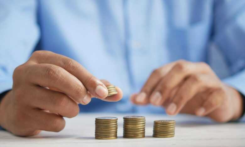 a person stacking coins on top of a table