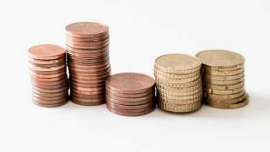 stacked round gold-colored coins on white surface