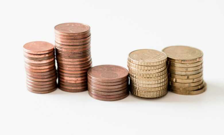 stacked round gold-colored coins on white surface