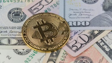 a bitcoin sitting on top of a pile of money