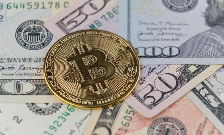 a bitcoin sitting on top of a pile of money