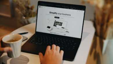 A person sitting at a table using a laptop computer