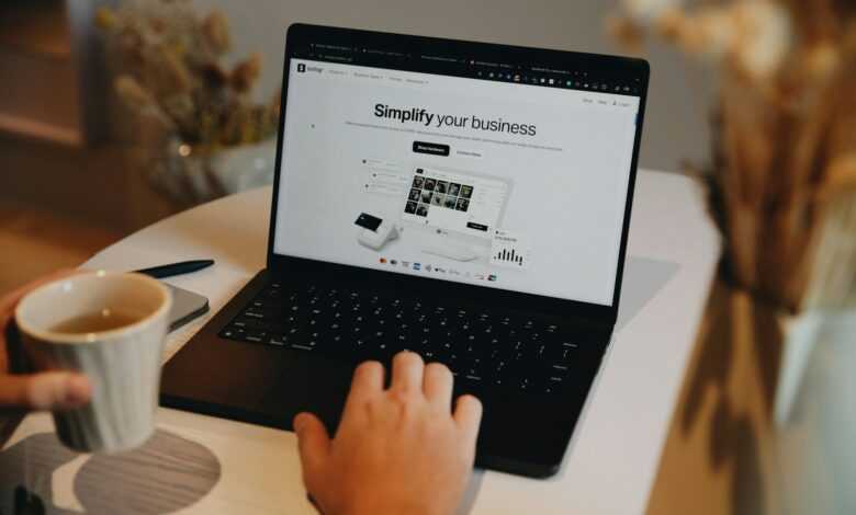A person sitting at a table using a laptop computer
